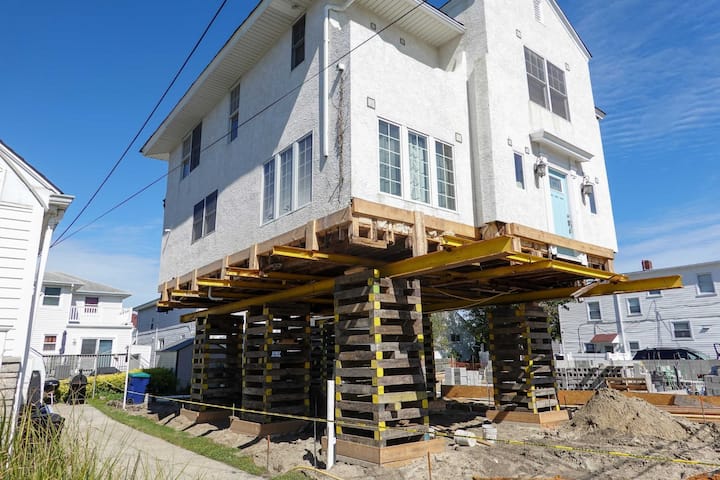 A team of professionals using specialized equipment to raise a house in Villages, preparing it for elevation and renovation